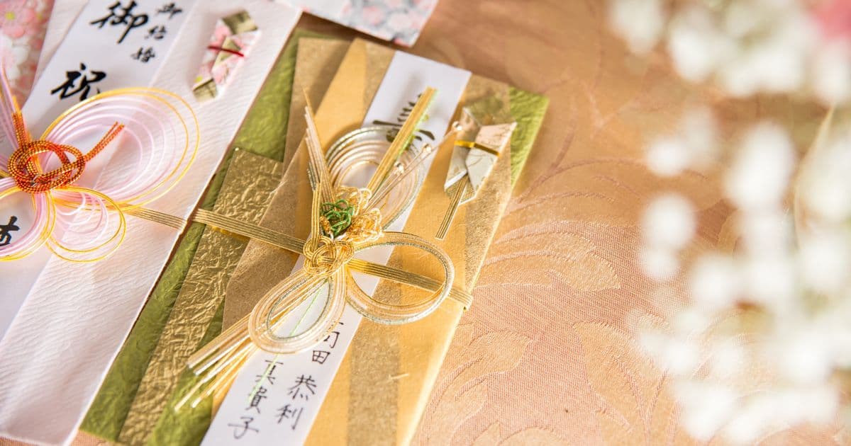 A gift wrapped in traditional Japanese noshi paper with a gold mizuhiki cord knot