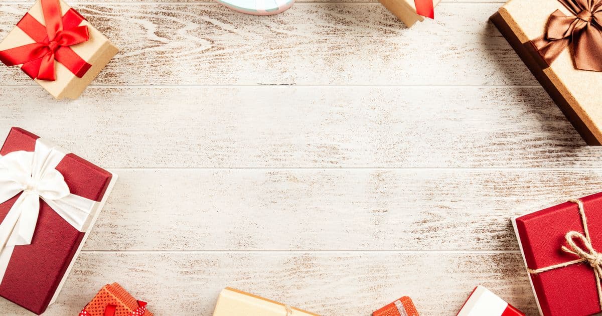 Several wrapped gift boxes with ribbons grouped on a wooden table